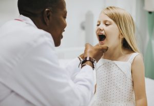 Young girl showing a dentist her teeth